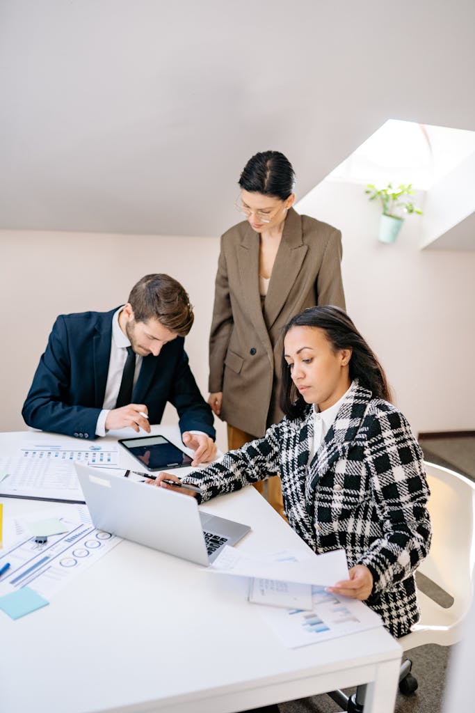 A diverse group of professionals working together in a bright, modern office setting.